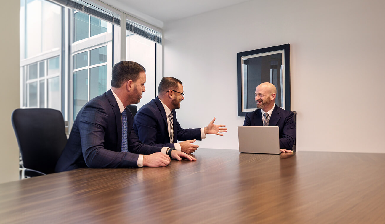 Three male attorneys have a meeting